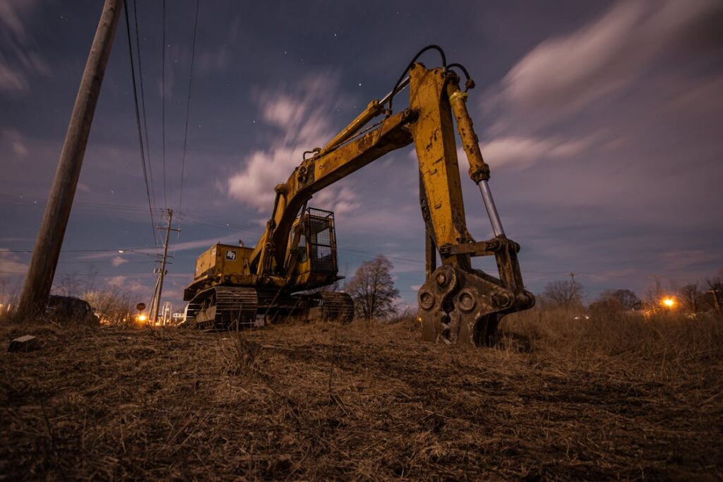 Nighttime photo of a yellow excavator under starry sky