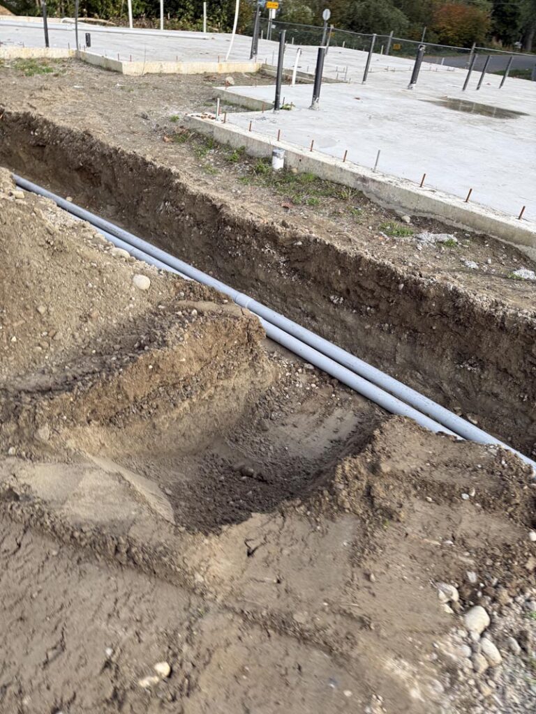 Construction trench with pipes and concrete foundations