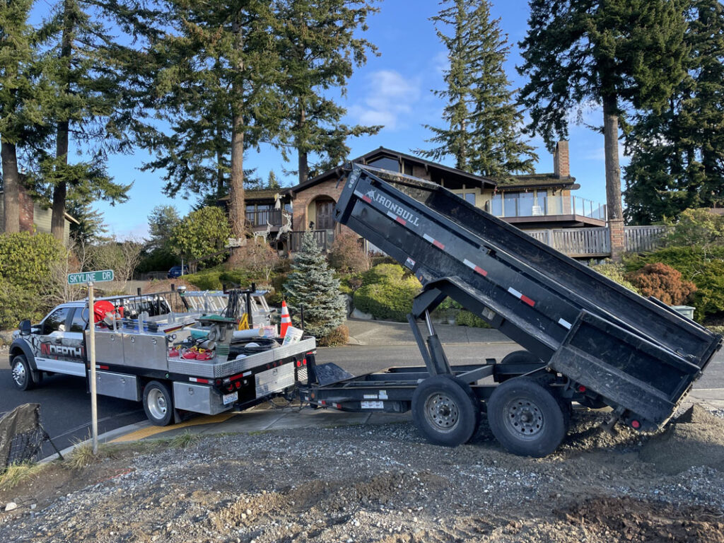 Dump truck unloading gravel near residential area