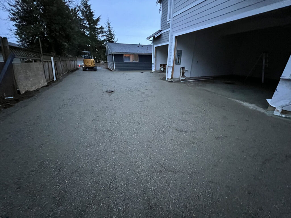 Twilight view of a residential driveway with vehicles