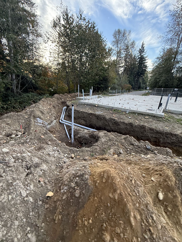 Construction site with exposed pipes in dug-up ground